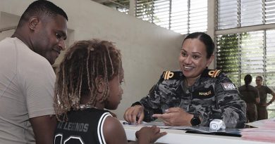 Lieutenant Donna Nabure, from the Australian Defence Force Malaria and Infectious Diseases Institute team, talks with a Papua New Guinea Defence Force member and his child during a health survey. Photo by Corporal Samuel Miller.