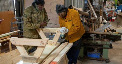 Private Luke Kennedy assists a fellow Amata community member with the construction of a bench seat. Story by Major Evita Ryan. Photo by Private Jack Hayes.