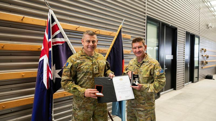 Major Stephen Ware, right, is presented with two Federation Stars by Major General Gregory Novak at Gallipoli barracks, Brisbane. Story by Captain Cody Tsaousis. Photo by Private Alfred Stauder.