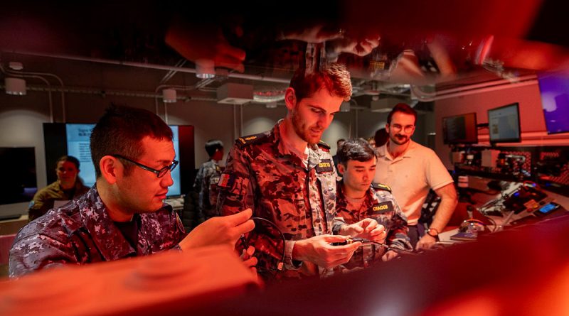 Personnel from the Royal Australian Navy, Japan Maritime Self Defence Force inspect hardware components during Exercise Blue Spectrum, at the Fleet Cyber Unit, Sydney. *This image has been digitally altered*. Story by Lieutenant Gordon Carr-Gregg. Photos by Corporal Lisa Sherman.