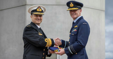 Vice Admiral David Johnston, left, passes the flag to his successor as Vice Chief of the Defence Force, Air Marshal Rob Chipman, during the handover ceremony at Russell Offices, Canberra. Photo by Rodney Braithwaite.