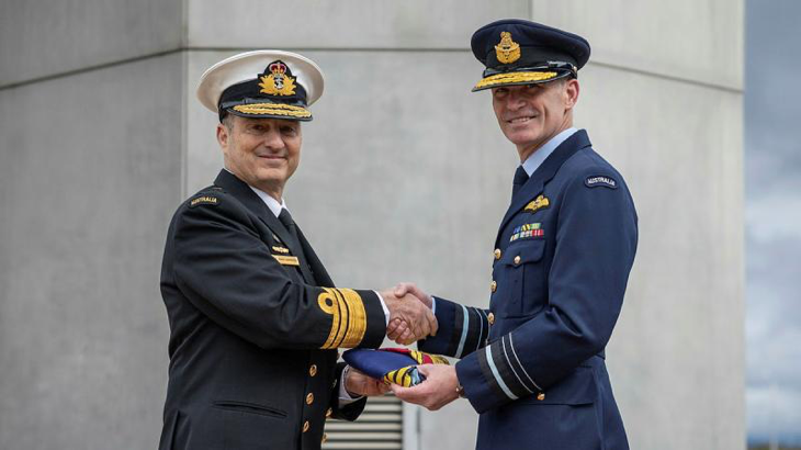 Vice Admiral David Johnston, left, passes the flag to his successor as Vice Chief of the Defence Force, Air Marshal Rob Chipman, during the handover ceremony at Russell Offices, Canberra. Photo by Rodney Braithwaite.
