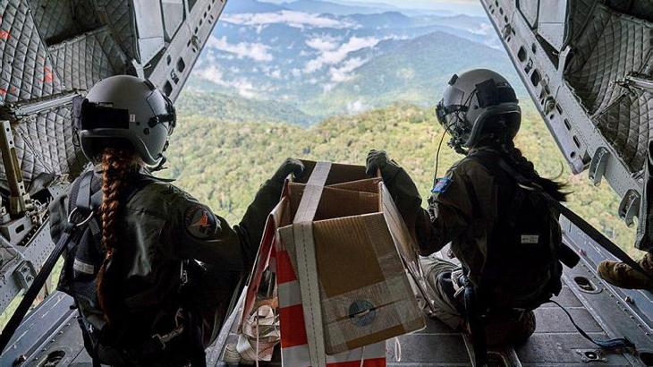 Corporal Monique Jeynes and Corporal Amanda Wintle on the ramp of a RAAF C-27J Spartan prepare to airdrop supplies over the Kokoda Track, Papua New Guinea, as part of the Defence Pacific Air Program.