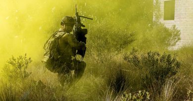 A soldier from 11th Brigade checks on his mates as he advances forward during an assault on an 'enemy' defensive position at Cowley Beach training area in northern Queensland. Story by Corporal Michael Rogers. Photo by Corporal Michael Currie.