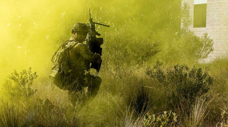 A soldier from 11th Brigade checks on his mates as he advances forward during an assault on an 'enemy' defensive position at Cowley Beach training area in northern Queensland. Story by Corporal Michael Rogers. Photo by Corporal Michael Currie.