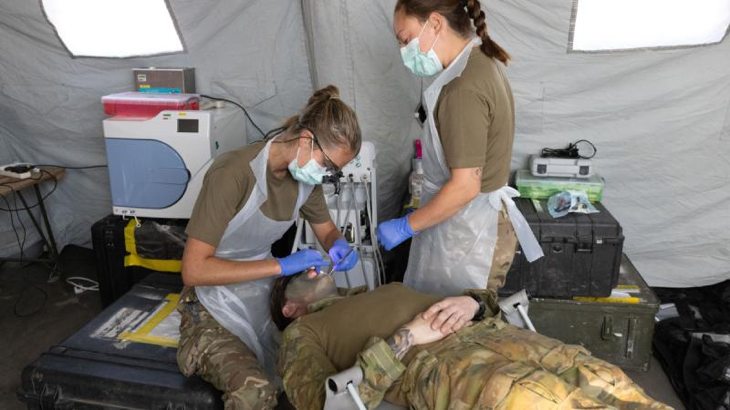 Royal Navy's dental surgeon Lieutenant Grace Smalley, left, and dental nurse Able Rate Jamie Shand, both from 40 Commando, perform a dental examination on an Australian Army soldier during Exercise Predator's Run at the Bradshaw Field Training Area. Story and photo by Sergeant Matthew Bickerton.