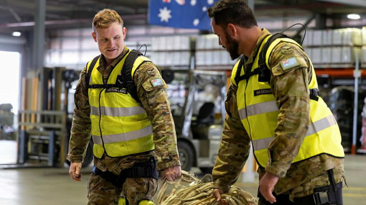 Leading Aircraftman Brandan Preston-Laws, left, and Aircraftman Luke Hasemann, of 23 Squadron, move equipment around while testing the Apex 2 exoskeleton at RAAF Base Amberley. Story by Sergeant Matthew Bickerton. Photo by Leading Aircraftwoman Taylor Anderson.