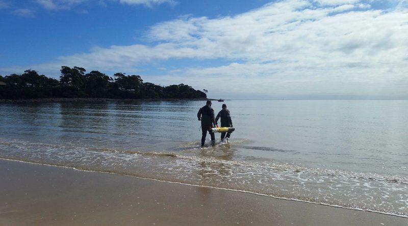 Students from Navy's Mine Warfare Faculty wade out in the water as part of training in Tasmania.