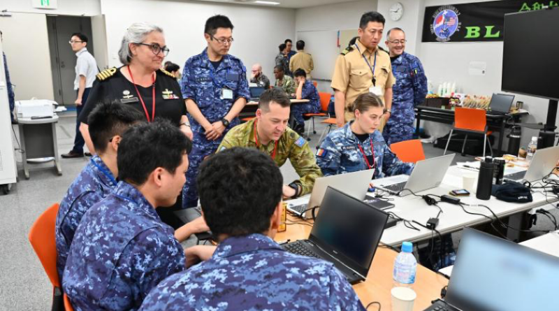 Commander Information Warfare Force Captain Catherine Gordon observes team 3 with Leading Aircraftman Shumack. Story by Lieutenant Commander Julian Thirkill.