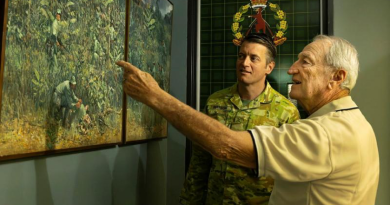 Lieutenant Colonel Ben Watson appreciates a painting of the 9th Battalion, The Royal Australian Regiment, in Vietnam with Veteran Dan Penman, right, at Gallipoli Barracks, Enoggera. Photo by Private Andrew Shaw.