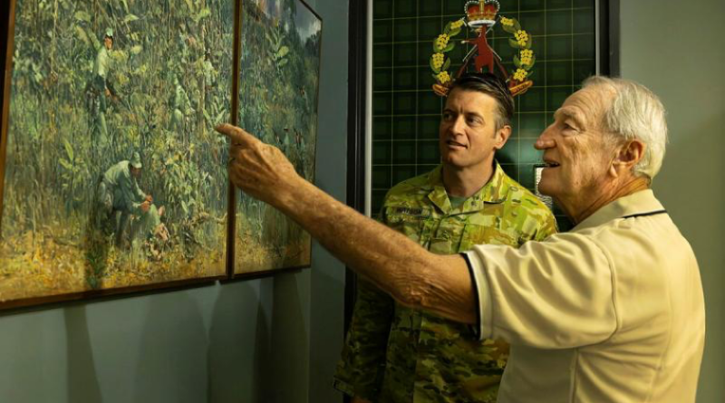 Lieutenant Colonel Ben Watson appreciates a painting of the 9th Battalion, The Royal Australian Regiment, in Vietnam with Veteran Dan Penman, right, at Gallipoli Barracks, Enoggera. Photo by Private Andrew Shaw.