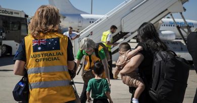 Australian High Commissioner to the Republic of Cyprus Fiona McKergow assists a woman and her family to board a bus after arriving in Larnaca, Cyrpus, by Australian-government chartered aircraft from Beirut, Lebanon. Photo by Corporal Nicole Dorrett.