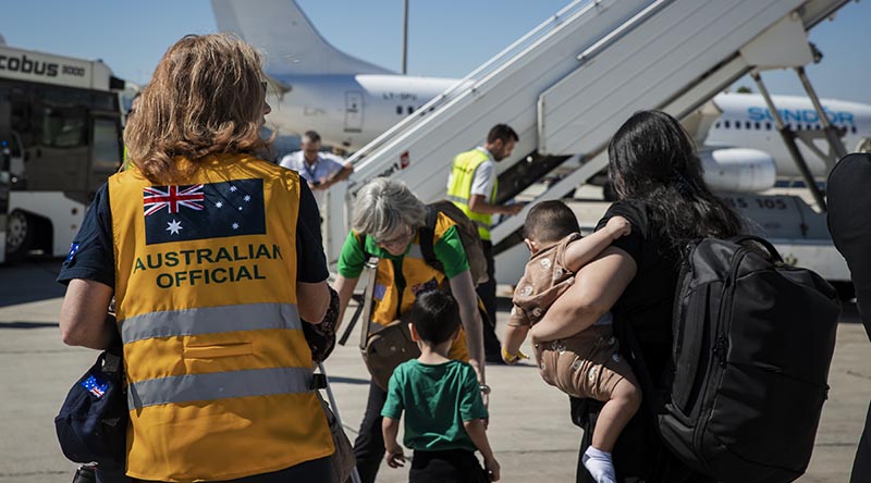 Australian High Commissioner to the Republic of Cyprus Fiona McKergow assists a woman and her family to board a bus after arriving in Larnaca, Cyrpus, by Australian-government chartered aircraft from Beirut, Lebanon. Photo by Corporal Nicole Dorrett.