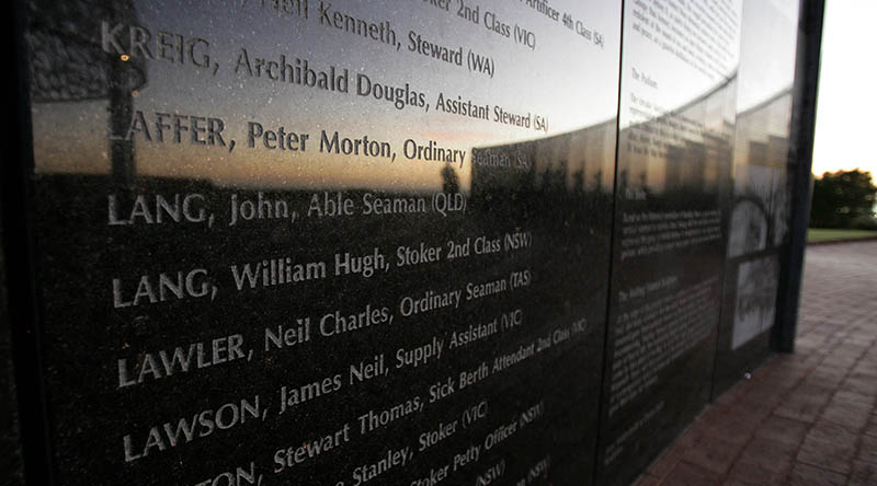 The memorial wall listing the crew of HMAS Sydney II at Mount Scott Geraldton. The interior concave side of the Wall of Remembrance, situated at the front of memorial, details the names of all 645 men who lost their lives. The centre piece is a dome mounted by seven pillars. Representing the seven states and territories of Australia. The dome is constructed by a canopy of silver gulls. A Stele is made of Stainless Stell and represents the bow of the HMAS Sydney II. A bronze sculpture of a a woman closest to the ocean. She wears an anchor necklace and holds hat against the breeze from the sea. Her anxious expression and her fixed gaze to the horizon. She represents a waiting woman grieven for her lost love one.