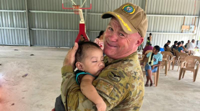 Deputy Mission Commander Pacific Partnership Wing Commander Scott Minchin holds a child during the mission in the Pacific. Story by Corporal Jacob Joseph.