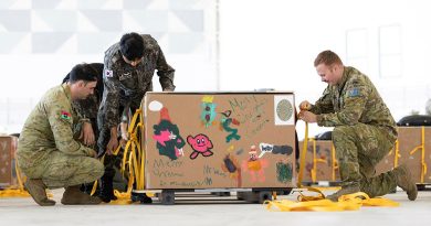 A member from the Republic of Korea Air Force, centre, helps Australian Army air dispatchers Corporal Ryan Cheevers and Private Kurt Matthews prepare a 'bundle' for Operation Christmas Drop 24. Story by Lieutenant Geoff Long. Photos by Leading Aircraftwoman Maddison Scott.