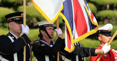 Able Seaman Alexandra Manthey, second from left, holds a UK flag during a ceremony in Busan, South Korea. Story by Lieutenant Commander Brendan Trembath. Photo by Yun, In Kyeong.