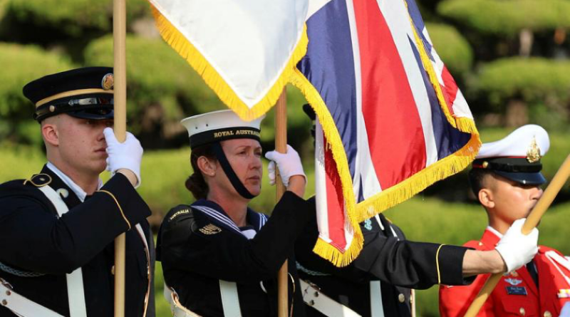 Able Seaman Alexandra Manthey, second from left, holds a UK flag during a ceremony in Busan, South Korea. Story by Lieutenant Commander Brendan Trembath. Photo by Yun, In Kyeong.