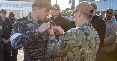 Rear Admiral Chris Cavanaugh, commander, Submarine Group 7, pins US Navy Submarine Warfare Device 'dolphins' on a Royal Australian Navy lieutenant commander during a pier-side quarters for the Virginia-class fast-attack submarine USS Vermont (SSN 792) in Japan. US Navy photo by Mass Communication Specialist 2nd Class Daniel G. Providakes.