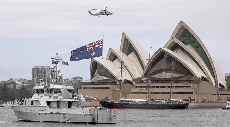 A Royal Australian Navy MH-60R Romeo helicopter with underslung Australian Flag flies past the Sydney Opera House during Australia Day festivities. Photo by Sergeant Tristan Kennedy.