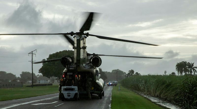 A member of the public from Halifax, QLD unloads critical supplies from a CH-47F Chinook helicopter from 5th Aviation Regiment during their assistance to North Queensland floods in February 2025. Story by Lieutenant Tahlia Merigan. Photo by Captain Chloe Elmwood.