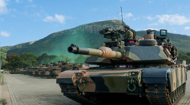 Personnel use an Australian Army M1A2 Abrams from 2nd Cavalry Regiment to provide security during the D Squadron raising ceremony at Lavarack Barracks, Townsville. Story by Captain Brittany Evans. Photo by Corporal Riley Blennerhassett.