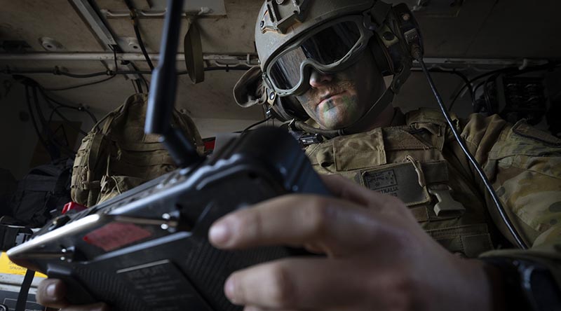 An Australian Army trooper from the 1st Armoured Regiment remotely controls a weapon system on an optionally crewed armoured vehicle during a demonstration in Puckapunyal, Victoria. Photo by Sergeant Tristan Kennedy.