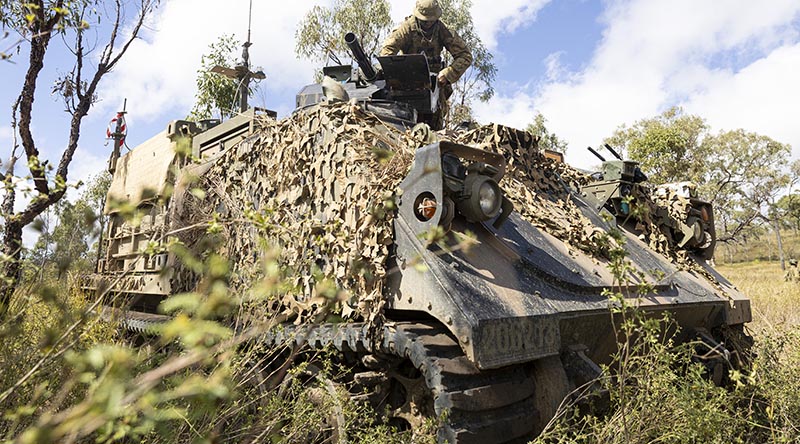 Australian Army soldier Lance Corporal Declan Bowditch from the 1st Armoured Regiment, performs maintenance on an M134D minigun remote weapon station attached to a modular robotic vehicle during Exercise Talisman Sabre at Townsville Field Training Area, Queensland. Photo by Lance Corporal Caitlyn Davill.