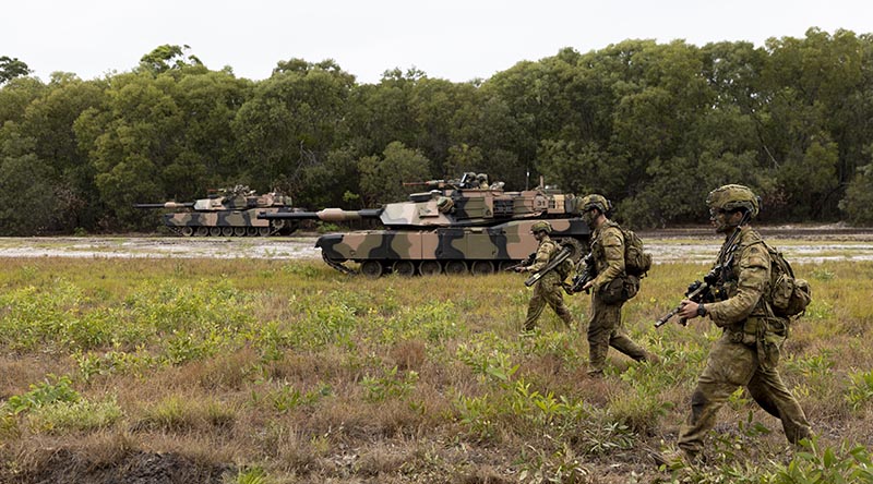 Australian Army soldiers from the 1st Battalion, Royal Australian Regiment, and the 2nd Cavalry Regiment, patrol through Cowley Beach Training Area during the combined arms training activity. Photo by Corporal Brodie Cross.