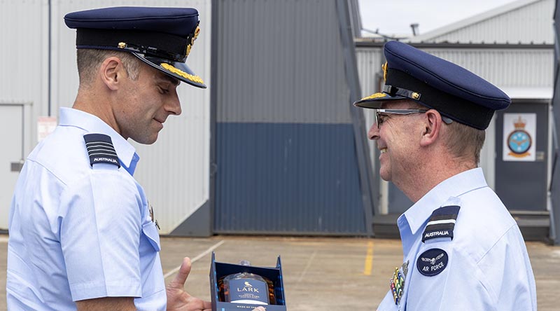 Group Captain Adam Saber gives a farewell gift to outgoing Commander Air Mobility Group, Air Commodore Bradley Clarke at a Change of Command ceremony at RAAF Base Richmond. Photo by Leading Aircraftwoman Mikaela Fernlund.