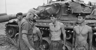 Corporal Bill Burton (far left) and colleagues from 1 Troop, C Squadron, 1st Armoured Regiment, RAAC, speak with General William Westmoreland, Commander, US Military Assistance Command Vietnam, about an enemy attack on Fire Support Base Coral. Photo by Kevin Thurgar – AWM file THU/68/0566/VN