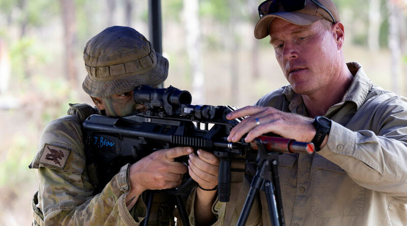 A soldier from the 2nd Cavalry Regiment aligns the transmitter from the Enhanced Personal Area Network during a live integrated systems display at Townsville Field Training Area, Queensland. Story by Leading Aircraftman Chris Tsakisiris. Photos by Lance Corporal Jessica Gray.