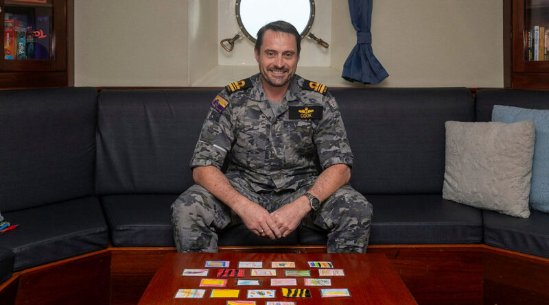 Lieutenant Commander Darcy Cook sits in the wardroom with patches gifted by preschoolers at Goodstart Child Care Centre Mangerton. Story by Lieutenant Marcus Middleton. Photos by Leading Seaman Zac Dingle.
