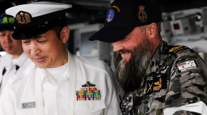 Warrant Officer Jonathan West talks with a Japan Maritime Self-Defense Force sailor on board JS Kumano as the ship transits to the Port of Brisbane. Story by Lieutenant Michael Wilson. Photos: byLeading Seaman Danyellah Hill.