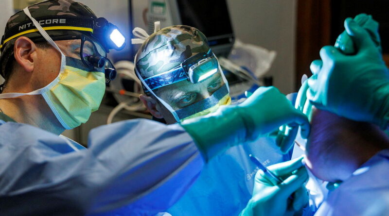 Army general surgeon Major Joseph Dawson, left, and orthopaedic surgeon Major Jarrad Stevens perform minor surgery on a member of Operation Render Safe in Papua New Guinea. Story by Captain Annie Richardson. Photos by Sergeant Andrew Sleeman.