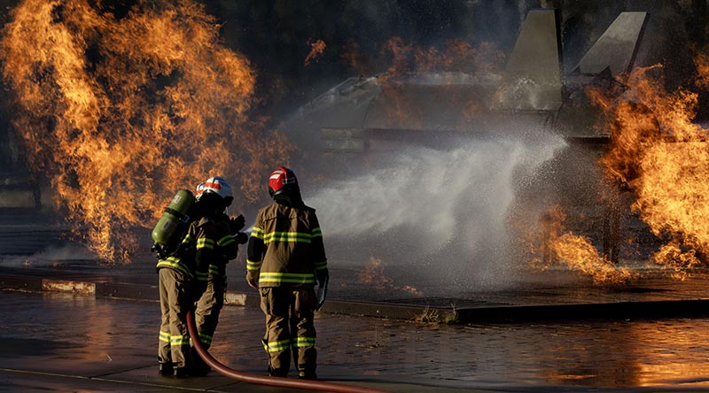 Students attending the Australian Defence Force Fire Fighter Basic Course fight a blaze on a simulated jet fighter at RAAF Base Amberley. Photo by Corporal Brett Sherriff.