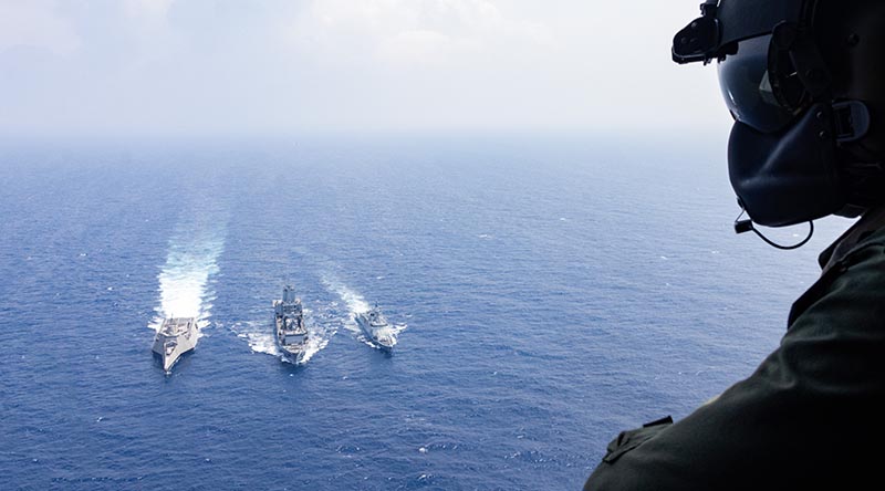 Leading Seaman Justin Howes flies over USS Santa Barbara, HMAS Supply and BRP Diego Silanga during a replenishment at sea off the west coast of Luzon. Photo by Leading Seaman Daniel Heuston.